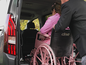 Woman in wheelchair, moving into vehicle