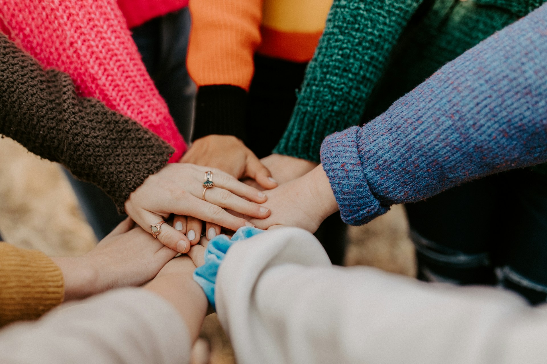 A group of friends all putting their hands together